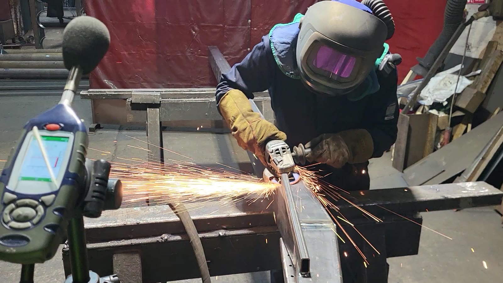 Sound level meter beside a metal grinding task