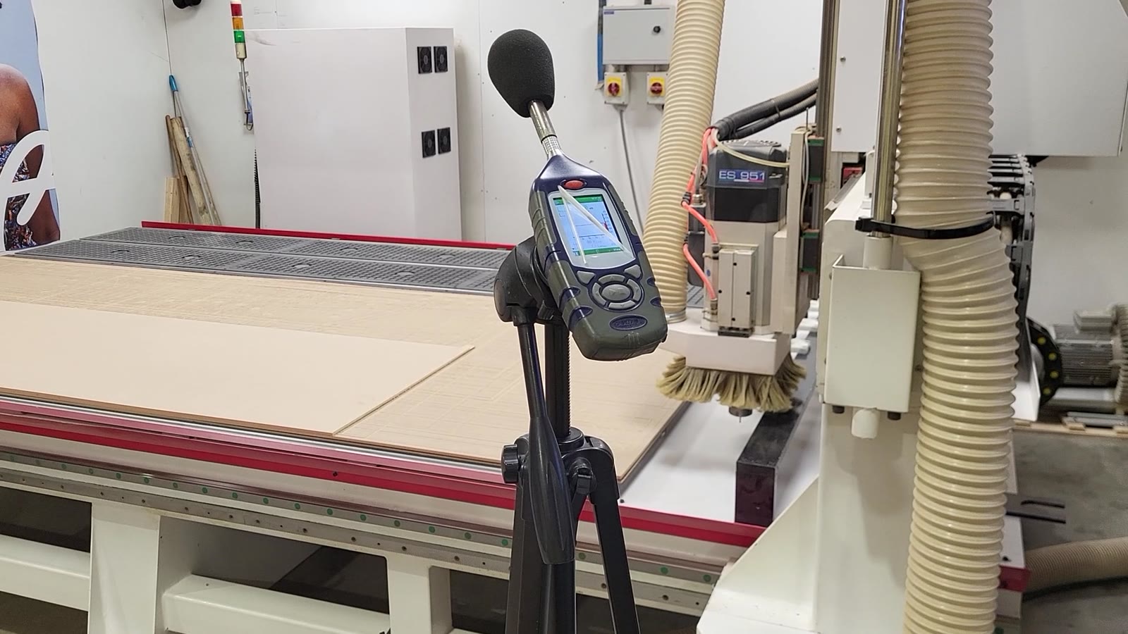 Sound level meter beside a CNC machining bed